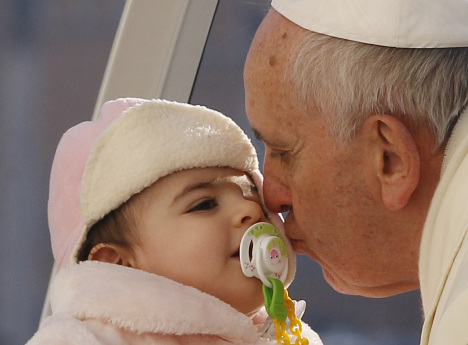 Pope kisses baby as he arrives to lead general audience in St. Peter's Square at Vatican